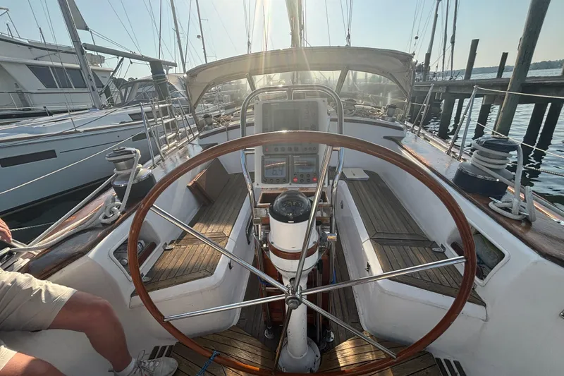 Slide: The Image of Cockpit of a 1988 Tayana 52 sailboat with wooden wheel and navigation instruments. - 28