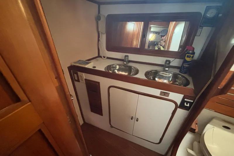 Slide: The Image of Interior of 1988 Tayana 52 yacht bathroom with dual sinks and wooden cabinetry. - 62