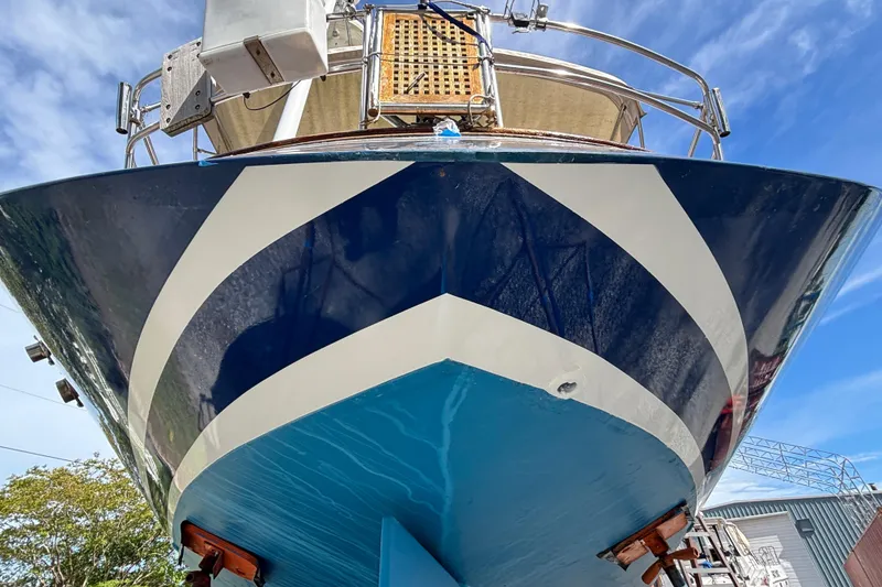 Slide: The Image of 1988 Tayana 52 sailboat with striking blue and white hull design, viewed from below. - 15