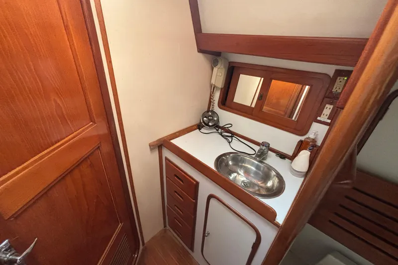 Slide: The Image of Compact bathroom interior of 1988 Tayana 52 yacht with wooden cabinetry and stainless steel sink. - 45
