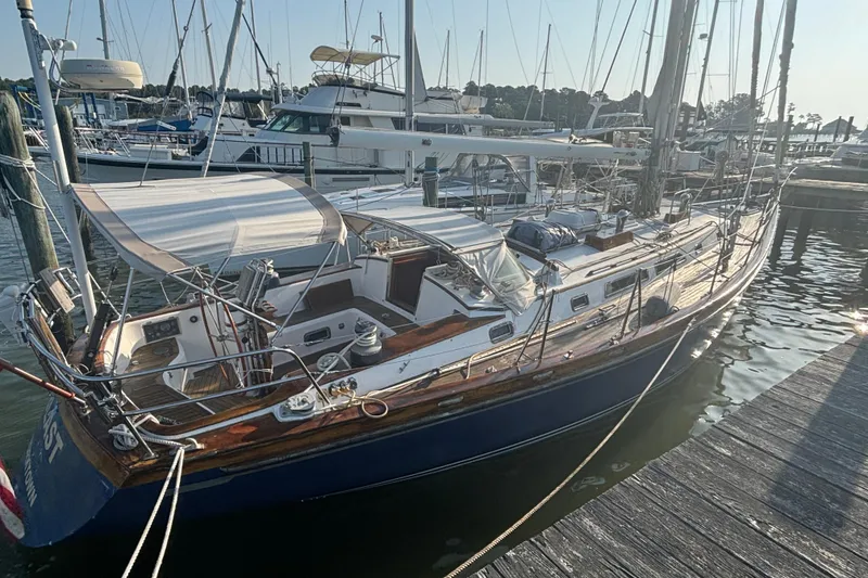 Slide: The Image of 1988 Tayana 52 sailboat docked at marina, featuring sleek design and spacious deck. - 23