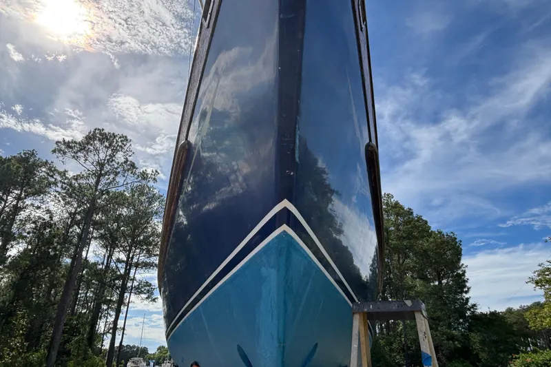 Slide: The Image of 1988 Tayana 52 sailboat hull, viewed from below, against a clear blue sky. - 12