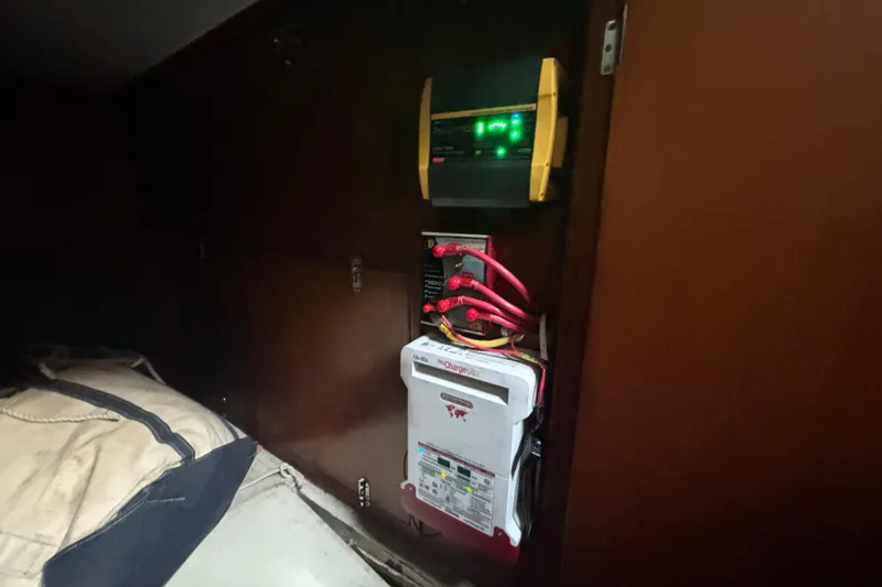 Slide: The Image of Electrical panel inside a 1988 Tayana 52 yacht, featuring wiring and control systems. - 46