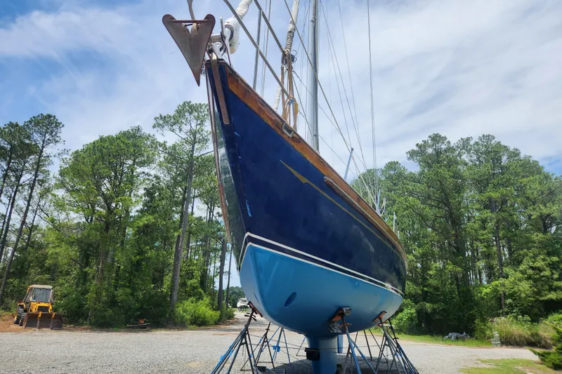Slide: The Image of 1988 Tayana 52 sailboat on land, surrounded by trees and blue sky. - 1