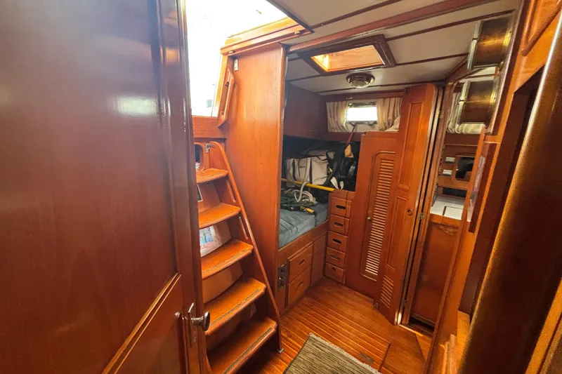 Slide: The Image of Interior of 1988 Tayana 52 sailboat with wooden cabinetry and cozy sleeping area. - 42