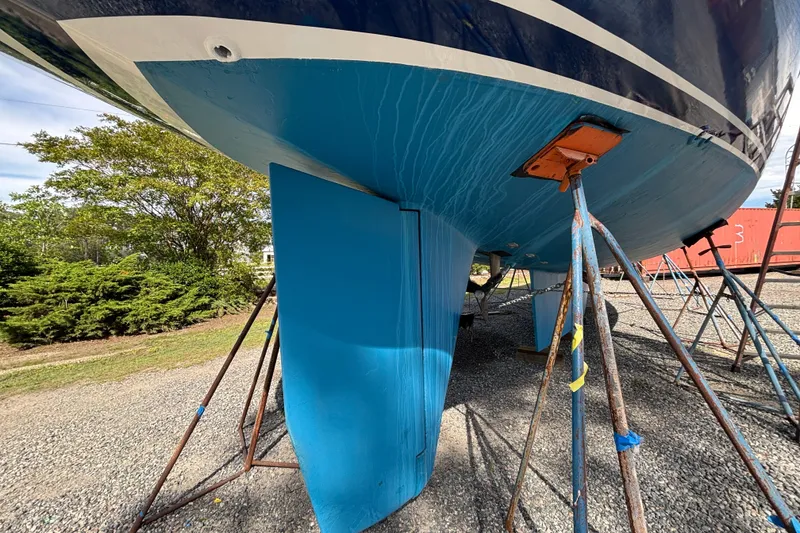 Slide: The Image of 1988 Tayana 52 sailboat hull on stands, blue paint, outdoor setting. - 17