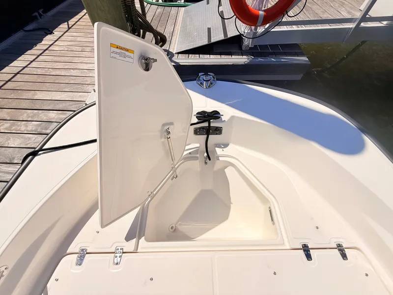 Slide: The Image of An open storage compartment on a Boston Whaler 190 Montauk, docked at a pier. - 43
