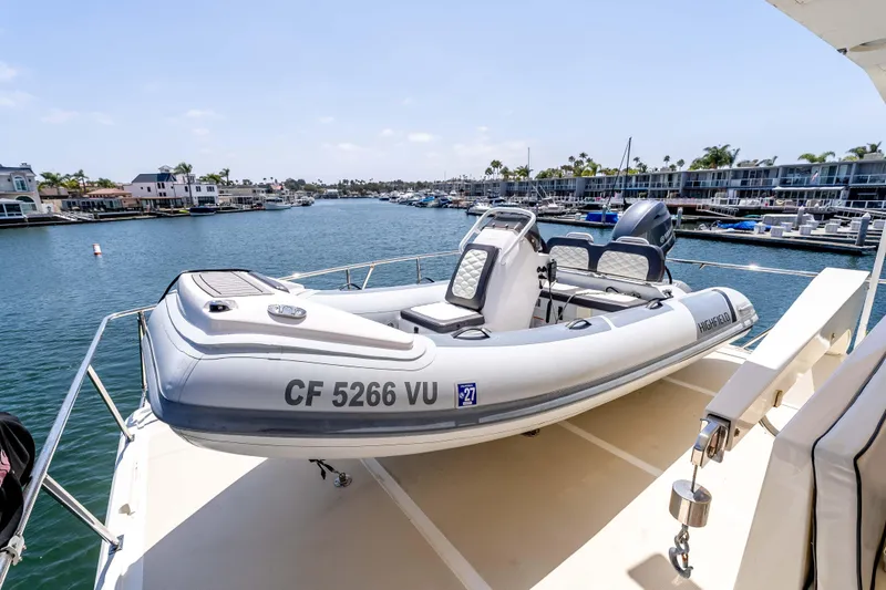 Slide: The Image of 2005 Offshore Yachts 54 Pilothouse with inflatable boat on deck, docked in marina. - 11