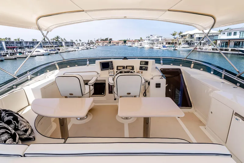 Slide: The Image of Pilothouse of 2005 Offshore Yachts 54, featuring helm and seating, overlooking marina. - 12