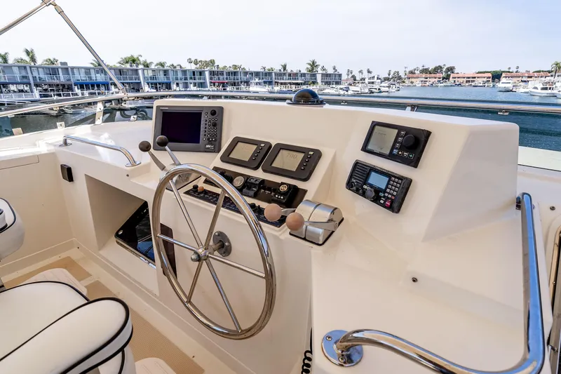 Slide: The Image of Pilothouse of 2005 Offshore Yachts 54, featuring navigation instruments and steering wheel. - 14