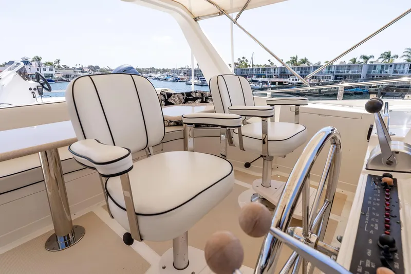 Slide: The Image of Pilothouse of 2005 Offshore Yachts 54, featuring elegant seating and steering wheel. - 16