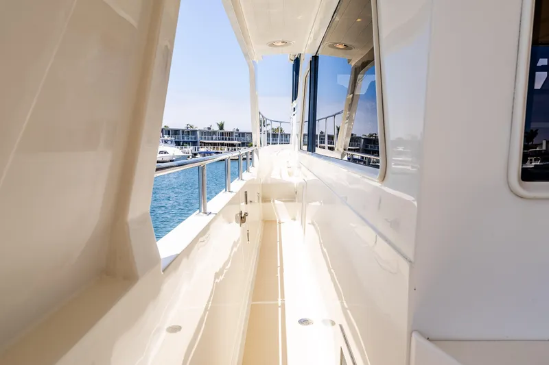 Slide: The Image of Side deck view of 2005 Offshore Yachts 54 Pilothouse, showcasing sleek design and waterfront. - 19