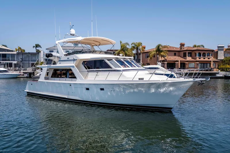 Slide: The Image of 2005 Offshore Yachts 54 Pilothouse cruising in a marina with waterfront homes. - 2