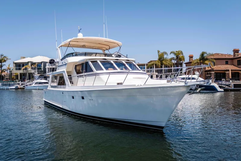 Slide: The Image of 2005 Offshore Yachts 54 Pilothouse in marina, surrounded by waterfront homes and palm trees. - 3