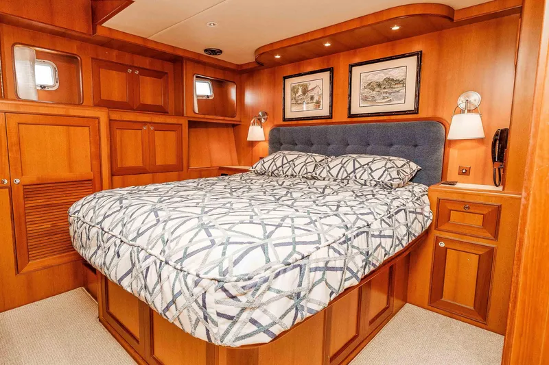 Slide: The Image of Luxurious 2005 Offshore Yachts 54 Pilothouse bedroom with elegant wood paneling and cozy bedding. - 33