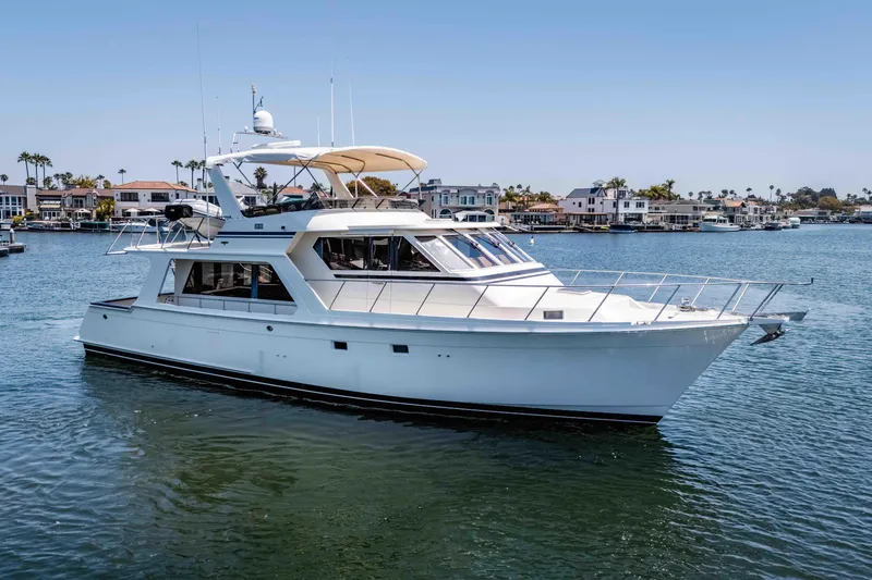 Slide: The Image of 2005 Offshore Yachts 54 Pilothouse cruising in a scenic waterfront setting. - 4