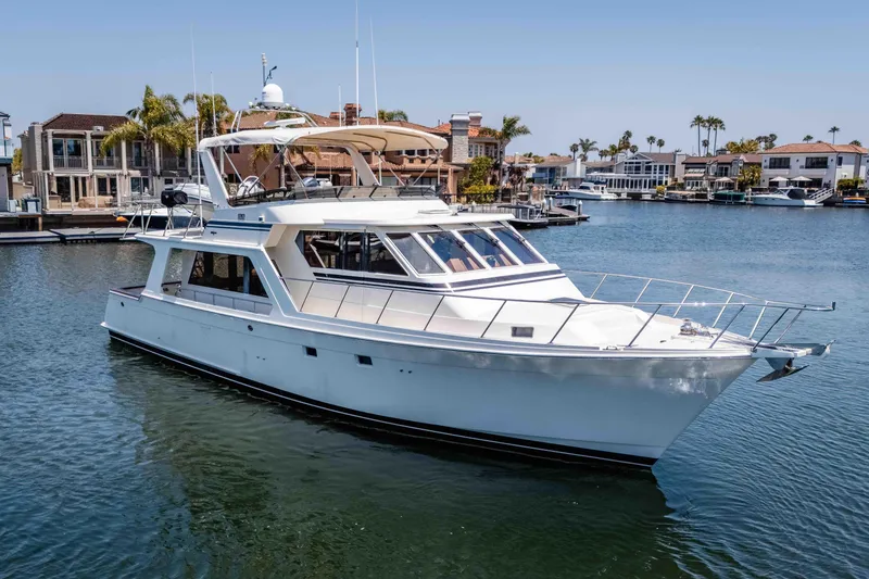 Slide: The Image of 2005 Offshore Yachts 54 Pilothouse cruising in a marina with waterfront homes. - 5