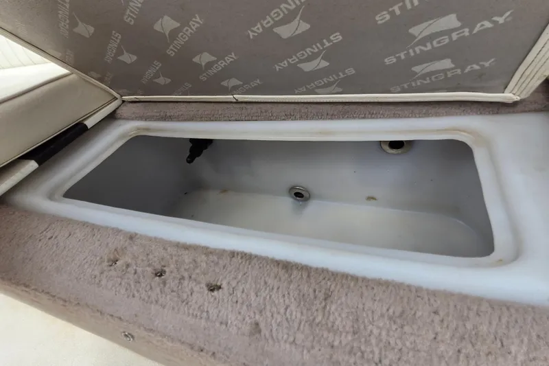 Slide: The Image of Storage compartment in a 2013 Stingray 191 LX boat, featuring a clean interior. - 11