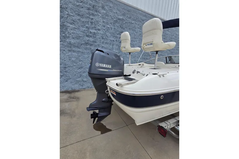 Slide: The Image of 2013 Stingray 191 LX boat with Yamaha outboard motor, parked on concrete. - 3