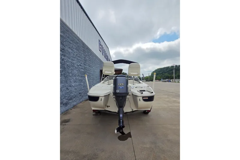 Slide: The Image of 2013 Stingray 191 LX boat with Yamaha 115 outboard motor, parked outdoors. - 4