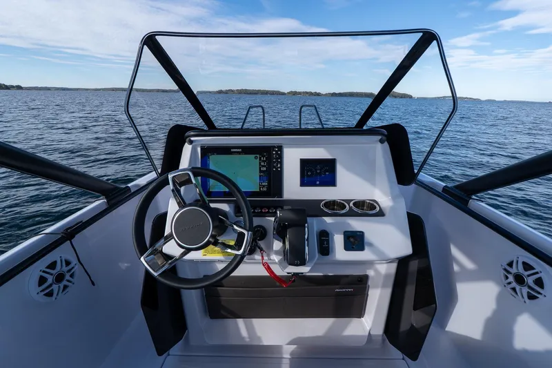 Slide: The Image of Axopar 22 T-Top 2026 helm on open water. - 13