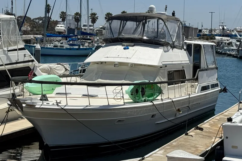 The Image of 1984 Spindrift Aft Cabin Motor Yacht docked at a marina, surrounded by other boats. - 1