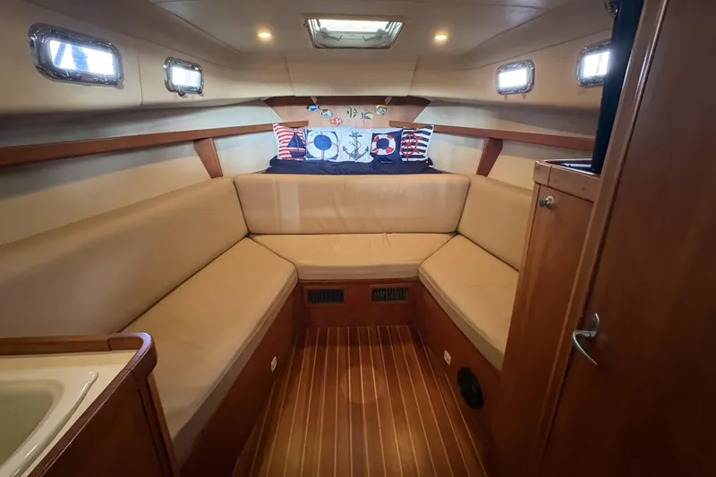 Slide: The Image of 2003 Mainship Pilot 30-II cabin interior with beige seating and nautical-themed decor. - 10