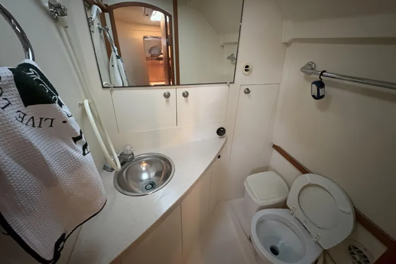 Slide: The Image of 2003 Mainship Pilot 30-II boat bathroom with sink, mirror, and toilet. - 12
