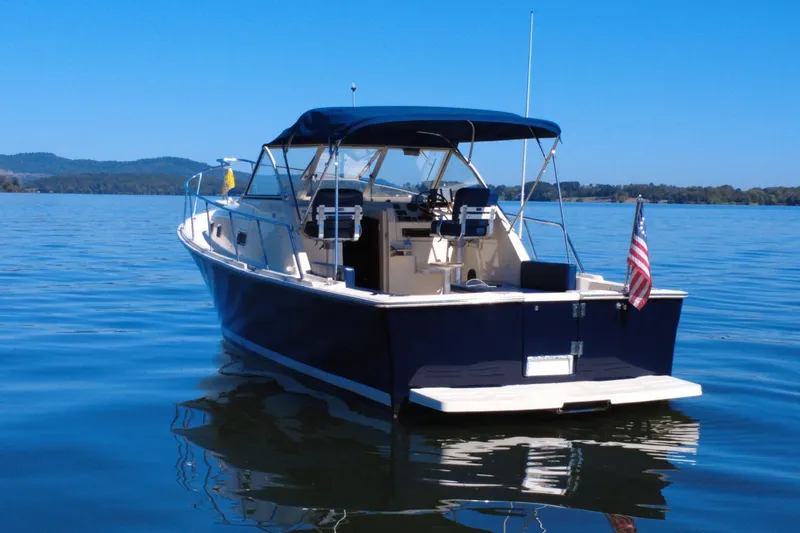 Slide: The Image of 2003 Mainship Pilot 30-II boat on calm water with American flag. - 3