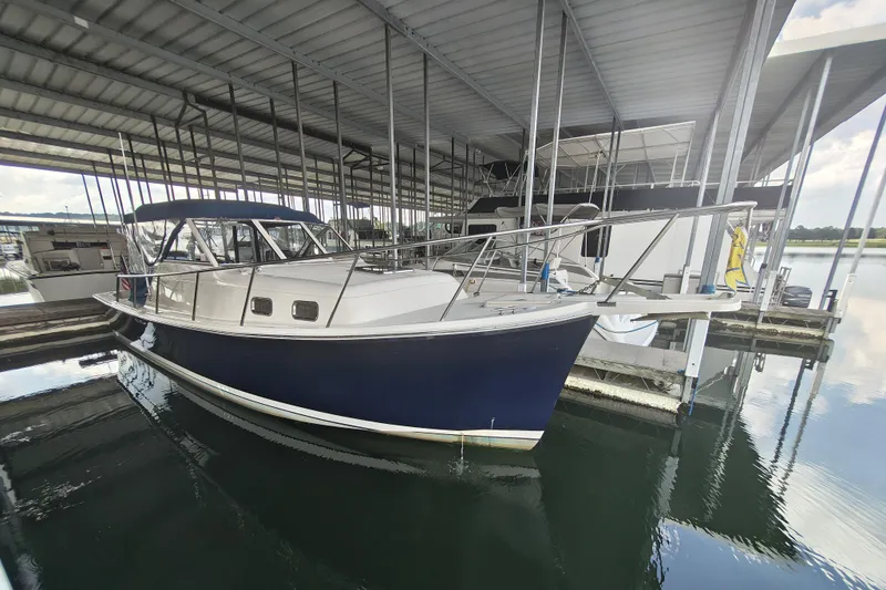 Slide: The Image of 2003 Mainship Pilot 30-II boat docked in a covered marina. - 4