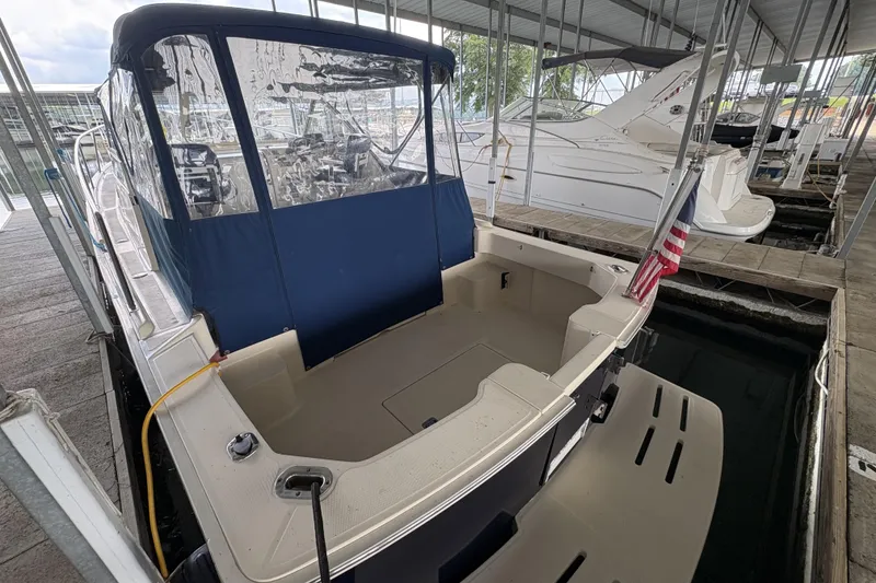Slide: The Image of 2003 Mainship Pilot 30-II docked, featuring a covered cockpit and American flag. - 6