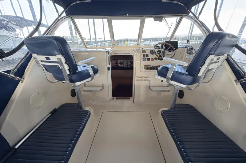 Slide: The Image of 2003 Mainship Pilot 30-II cockpit with blue seating and steering wheel, showcasing nautical design. - 8