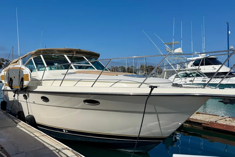 Slide: The Image of 1998 Tiara Yachts 3500 Express docked at marina under clear blue sky. - 2