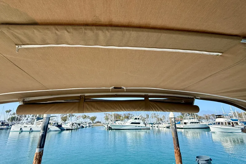 Slide: The Image of 1998 Tiara Yachts 3500 Express with canopy, docked in a marina with other boats. - 21