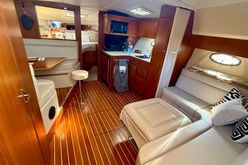 Slide: The Image of Luxurious interior of a 1998 Tiara Yachts 3500 Express, featuring elegant wood finishes and cozy seating. - 22