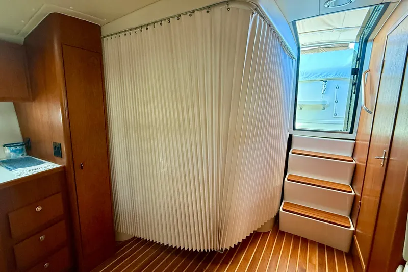 Slide: The Image of Interior of 1998 Tiara Yachts 3500 Express with wooden cabinetry and stairs. - 24