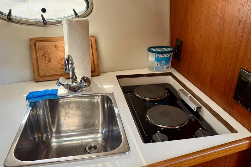 Slide: The Image of 1998 Tiara Yachts 3500 Express kitchen with sink, stove, and wooden cutting board. - 28