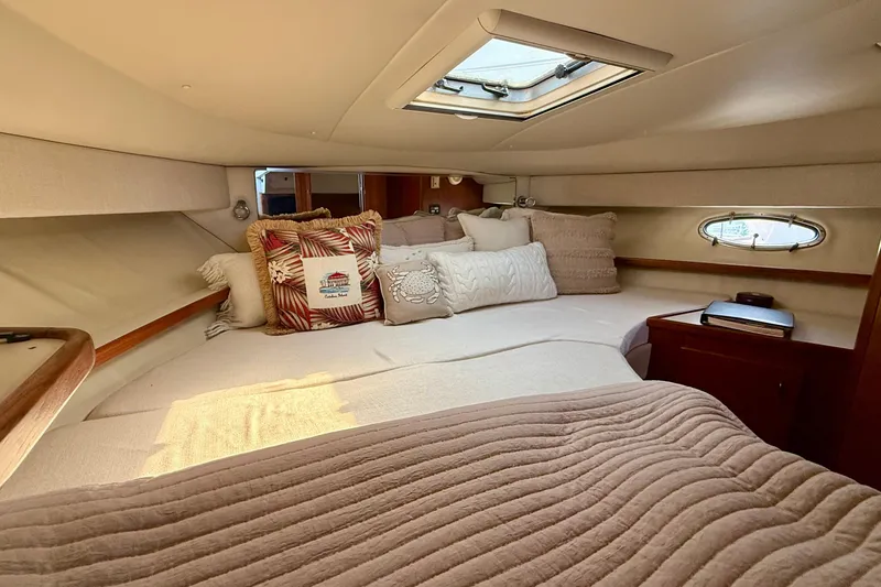Slide: The Image of Cozy cabin interior of 1998 Tiara Yachts 3500 Express with plush bedding and porthole window. - 31