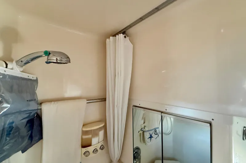 Slide: The Image of 1998 Tiara Yachts 3500 Express bathroom with shower, curtain, and mirror. - 34