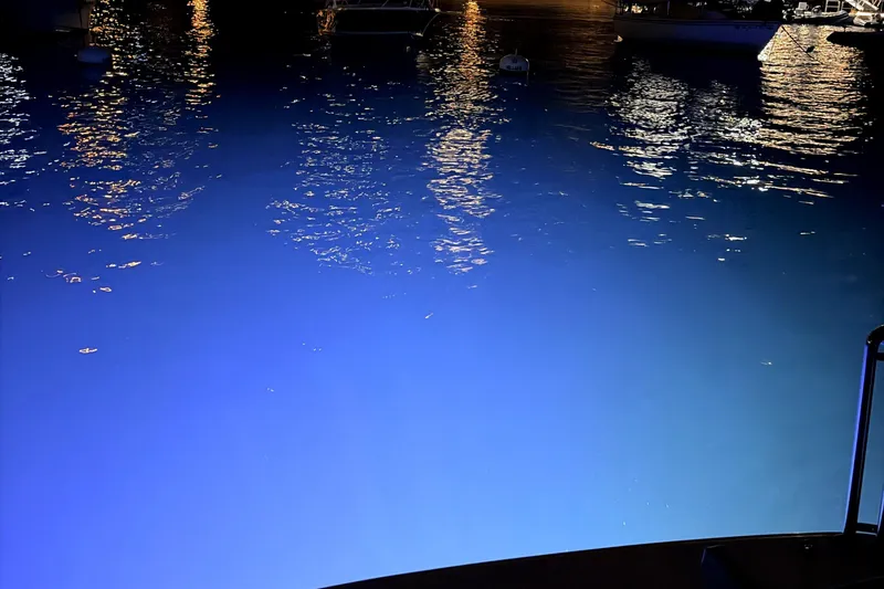 Slide: The Image of Nighttime marina view with reflections on water, featuring a 1998 Tiara Yachts 3500 Express. - 4