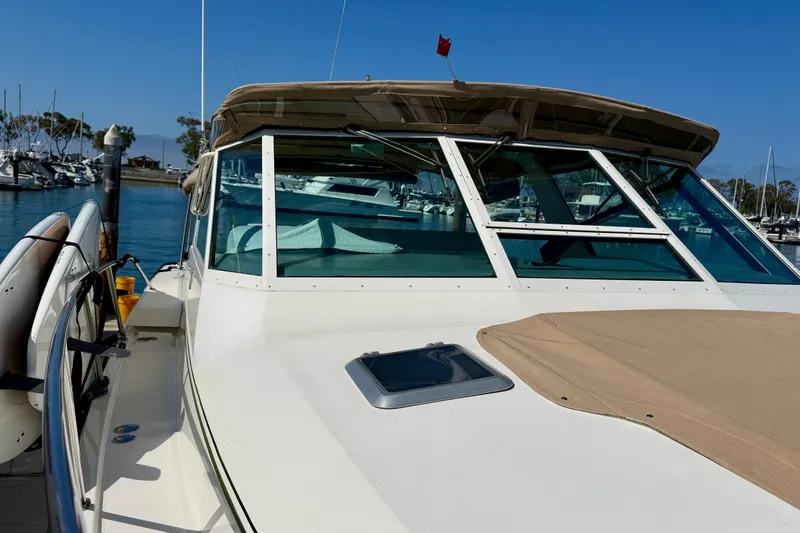 Slide: The Image of 1998 Tiara Yachts 3500 Express docked at marina under clear blue sky. - 6