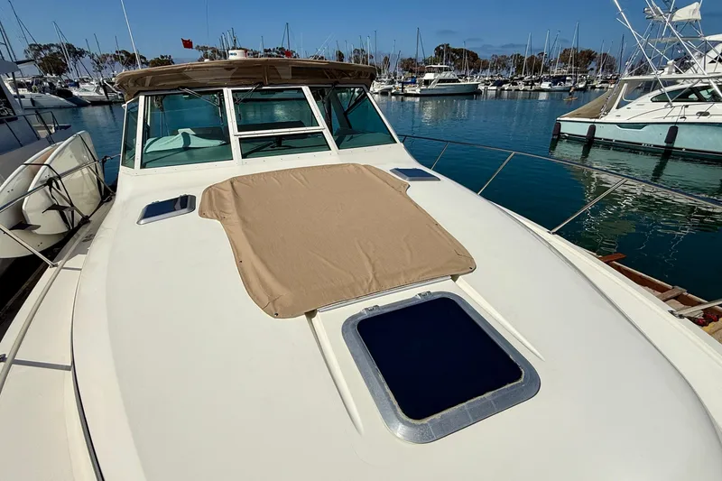 Slide: The Image of 1998 Tiara Yachts 3500 Express docked in a marina, showcasing sleek design and spacious deck. - 7