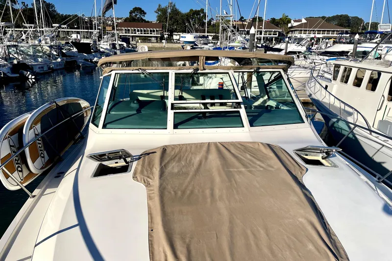 Slide: The Image of 1998 Tiara Yachts 3500 Express docked at a marina, showcasing its sleek design and covered deck. - 8