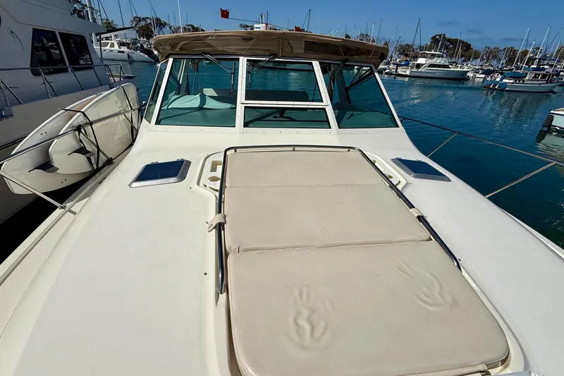 Slide: The Image of 1998 Tiara Yachts 3500 Express on water, featuring spacious deck and marina backdrop. - 9