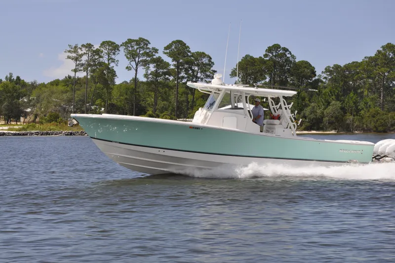 The Image of 2023 Regulator 37 boat cruising on a lake with lush green trees in the background. - 0