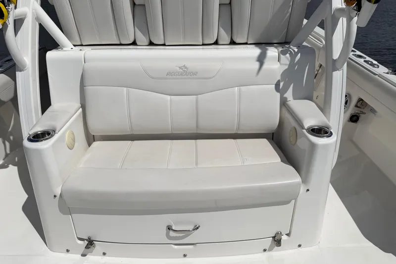 Slide: The Image of White seating area on a 2023 Regulator 37 boat, featuring cup holders and armrests. - 12