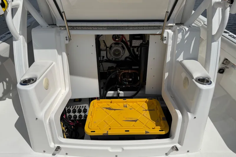 Slide: The Image of 2023 Regulator 37 boat storage compartment with yellow container and electrical components. - 13