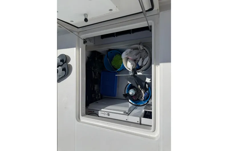 Slide: The Image of Storage compartment on a 2023 Regulator 37 boat, containing cleaning supplies and equipment. - 14