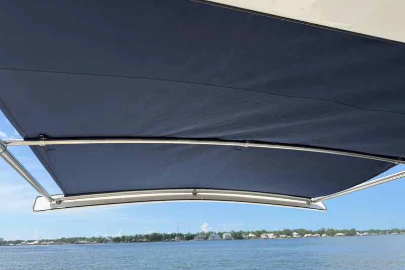 Slide: The Image of 2023 Regulator 37 boat with navy blue canopy over calm waters. - 21