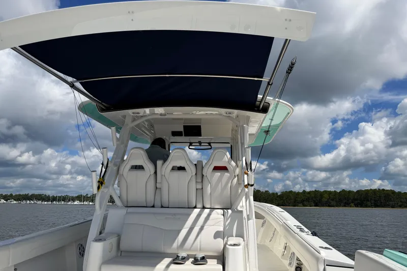 Slide: The Image of 2023 Regulator 37 boat interior with seating, canopy, and scenic water view. - 22